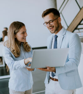 young business couple working discussing by laptop office front their team 1
