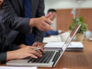 unrecognizable woman working laptop office man standing watching pointing 1