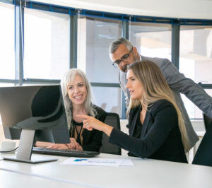 successful business team watching content computer monitor together discussing project sitting workplace pointing display business communication teamwork concept 1